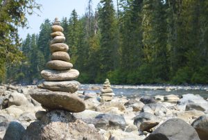 pallet of stacking gravels on the top of a bigger rock next to the river in natural surrounding.